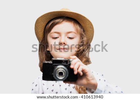 Cute little girl takes picture with vintage camera