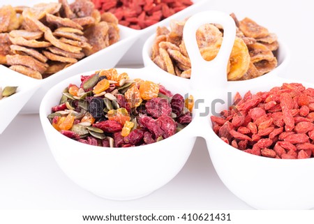 Dried fruits, berries and seeds in bowls closeup picture.