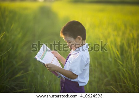 Asian boy standing reading the field,Children's books