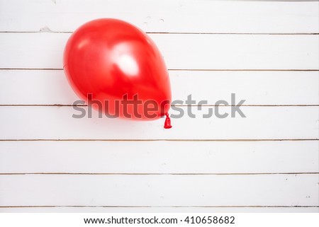 White wooden background with red balloon Royalty-Free Stock Photo #410658682