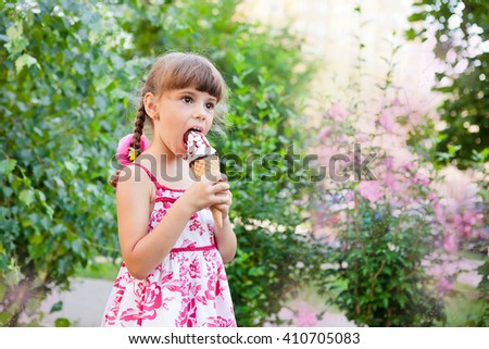 girl with pigtails eating ice cream in a cone