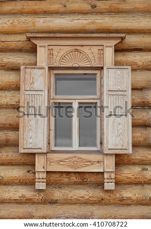 Closeup shot of a beautiful, old fashioned, Russian style window with intricately carved woodwork and shutters.