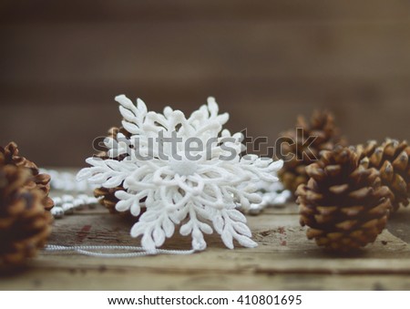 Christmas, winter background with white snowflake on a old wooden surface.  Vintage filter and soft focus picture