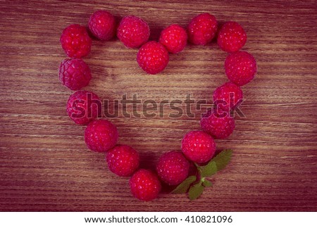 Vintage photo, Heart shaped fresh raspberries on wooden table, healthy food and dessert, symbol of love