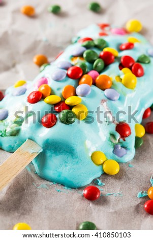 Melting ice cream covered with candies