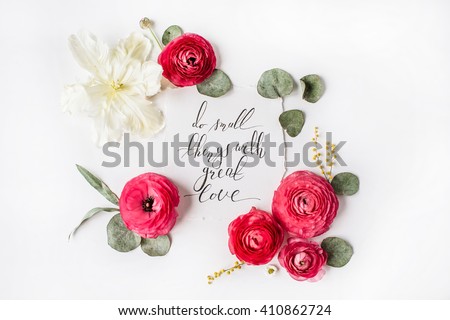 inspirational quote "Do small things with great love" written in calligraphy style on paper with pink, red roses, ranunculus, white tulip and leaves isolated on white background. Flat lay, top view Royalty-Free Stock Photo #410862724