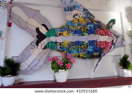 A fish to train of iron plates of several colors on a wall