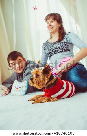 Family with a dog  lie on the white bed