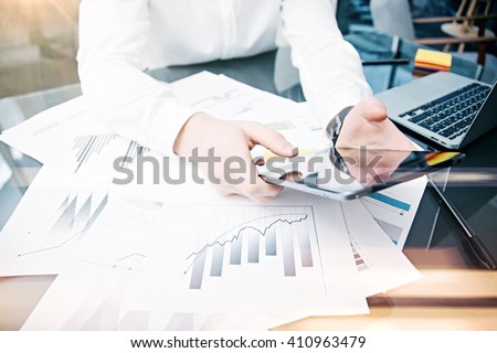 Picture man touching modern tablet screen.Trader manager working new private banking project office.Using electronic device.Graphic icons,stock exchanges reports table. Horizontal.Film effect