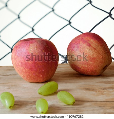 Closed up new and fresh apple and grapes on wood background