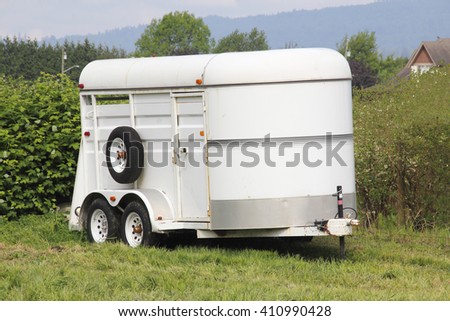 A white, lightweight trailer used for transporting horses/Lightweight Horse Trailer/A trailer used for transporting horses.  Royalty-Free Stock Photo #410990428
