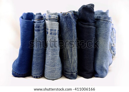 Blue jeans pants pile on a white background.