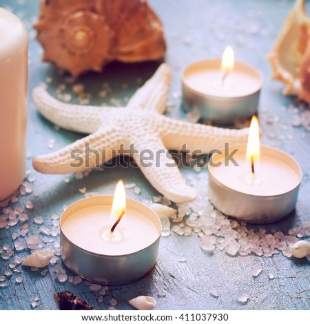Starfish is surrounded by burning candles, image tinted