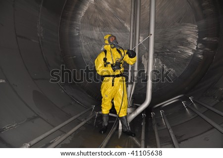 man in chemical suit inside of cargo tank on chemical tanker for cleaning operation Royalty-Free Stock Photo #41105638