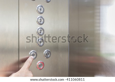 Close up hand pressing silver elevator button