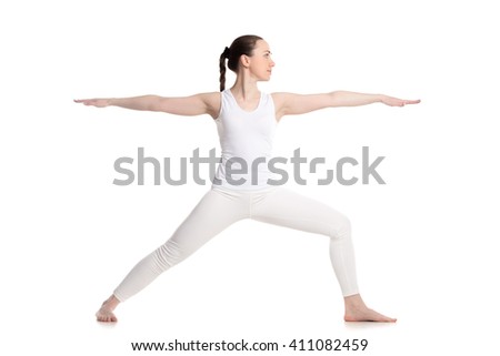 Sporty beautiful young woman in white sportswear doing lunge exercise, Warrior II posture, Virabhadrasana 2, profile view, studio shot, isolated, part of large photo series