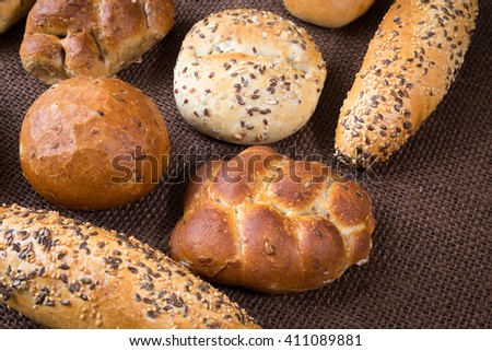 Different sorts of wholemeal breads and rolls on brown background