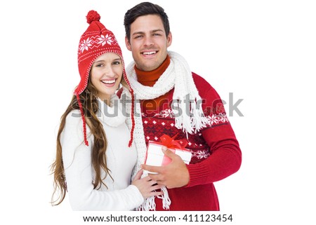 Happy couple with winter clothes holding gift box on white backgrond