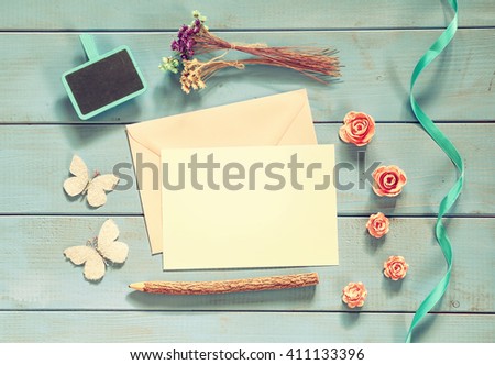 vintage mockup with flowers and blank letter on wooden background. vintage filtered and toned