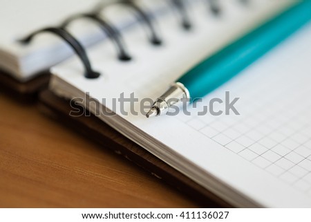 Blank note paper with pen on wood background