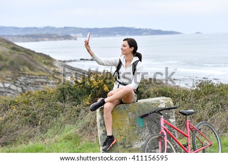 Woman on biking day taking picture with smartphone