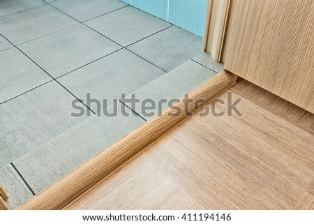 Doorstep before entrance to the bathroom with grey floor  