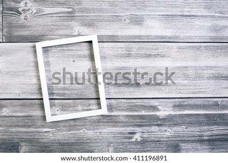 Empty white picture frame on antique wooden wall. Mock up