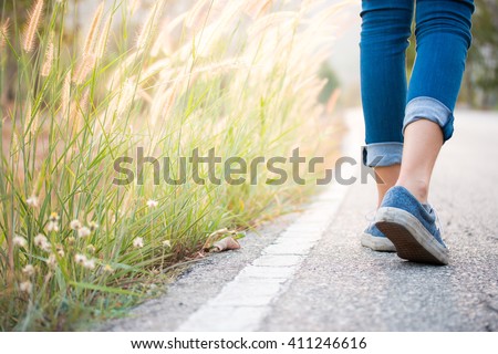 Walking women jeans and sneaker shoes Royalty-Free Stock Photo #411246616