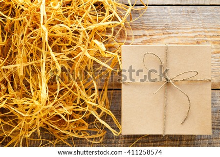 kraft gift box on wooden table with raffia or twine