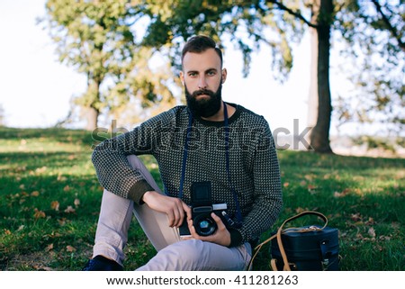 hipster man photographer is making landscape photography with retro old film camera medium format