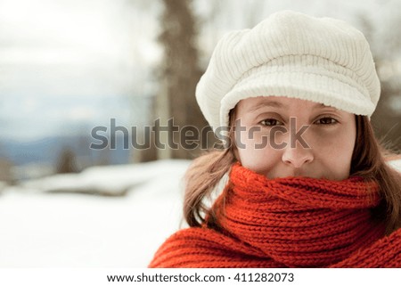 beautiful relaxed woman with red scarf in a snowy landscape portrait