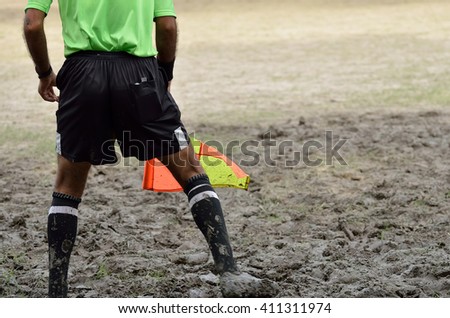 Soccer assistant referee is running with flag.