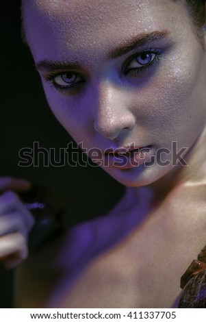 Portrait of a young beautiful girl Europeans shot on a black background with color filters