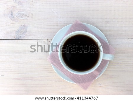 White wooden background with cup of coffee, simple composition, bright white color