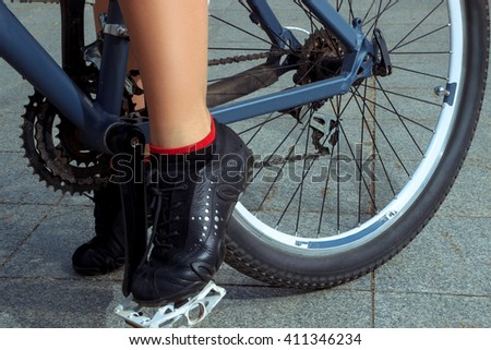 horizontal picture of female legs in sneakers on the bicycle pedal