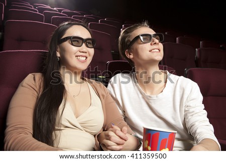 Young couple sitting at the cinema wearing 3d glasses, watching a film. Cinema photo series