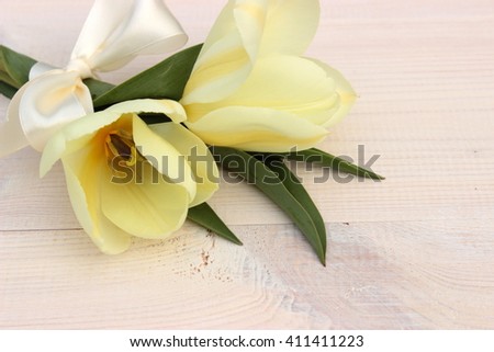 White card with fresh bunch of cute white tulips decorated with white ribbon with bow