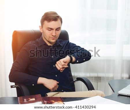 Square picture of businessman looking on his wrist watches