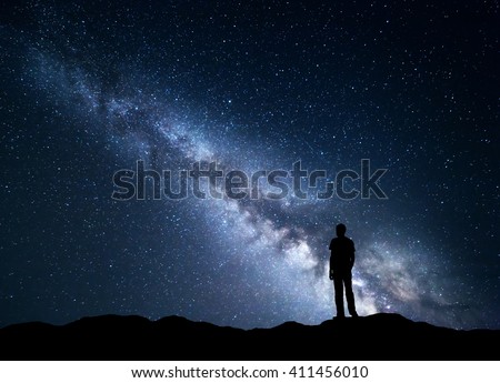 Landscape with blue Milky Way. Night sky with stars and silhouette of a happy man on the mountain. Beautiful Universe. Space background