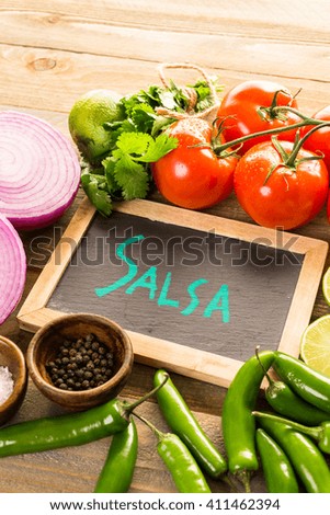 Fresh salsa in white bowl with ingredients.