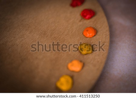 Image of wooden palette with oil paints and brushes