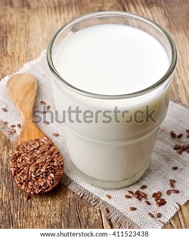 Flax milk and flax seed on a wooden background