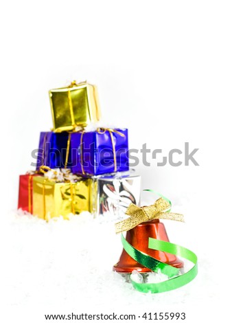 Christmas gifts with a red bell in forground