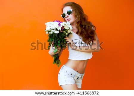 fashion girl with flowers and tan skin posing on the wall,Closeup attractive beautiful woman with fluffy red hair girl,smiling, having fun on the white wall,wearing vintage sunglasses,outfit 