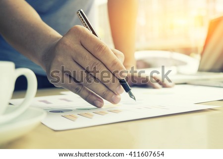 Man writing paper at the desk in office, morning light, selective focus, vintage color