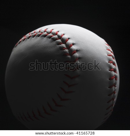 A closeup of a baseball ball on black background - still life