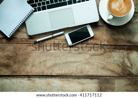 office stuff with smart phone laptop and coffee cup mouse notepad top view shot.