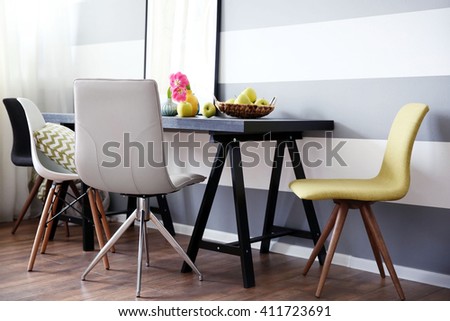 Modern room interior with table, chairs and pictures on the wall