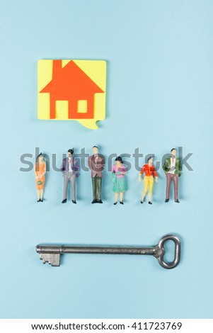 Real Estate concept. Blank speech bubbles and people toy figures Construction, building. Paper model house with key on blue background. Top view. Copy space for text