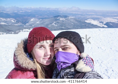 man and woman doing selfie in the snowy mountains